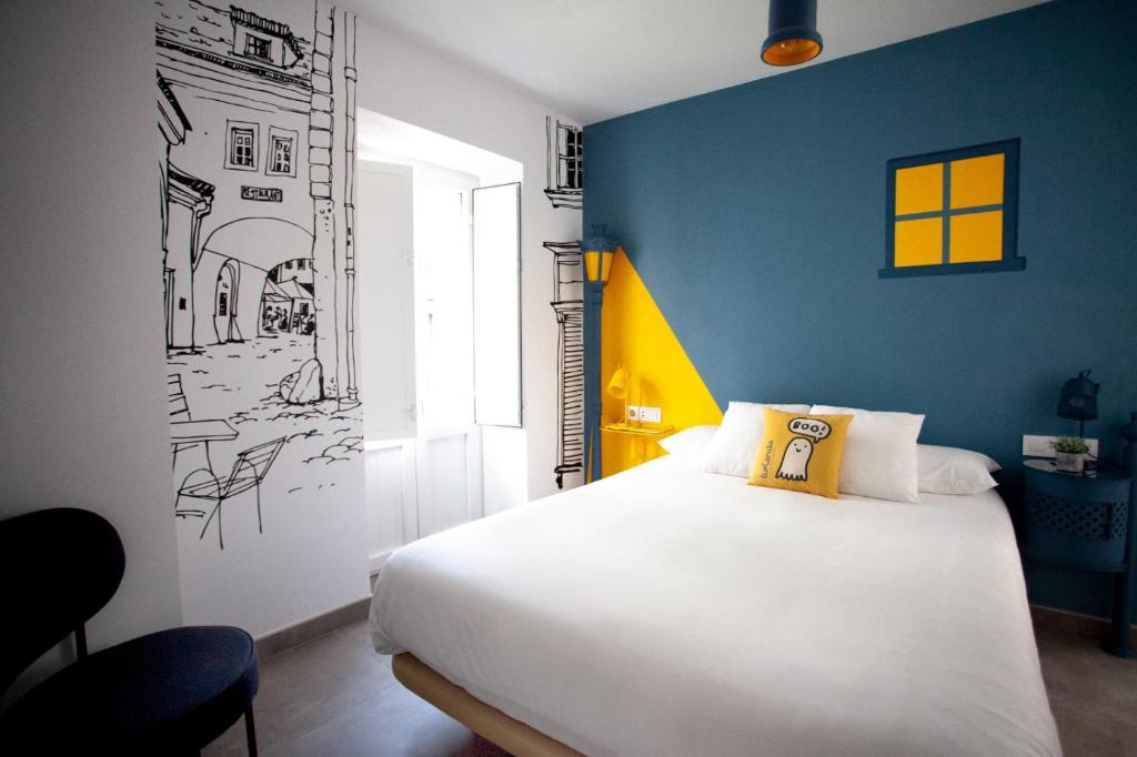 Un dormitorio con una cama blanca y una pared azul. en Lukanda Hospec Olehousing, en Sevilla