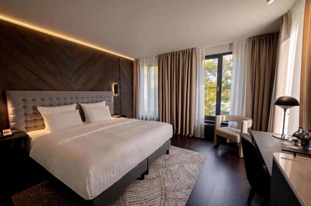Una habitación de hotel con una cama grande y un escritorio. en Pullman Riga Old Town - Renovated 2025, en Riga