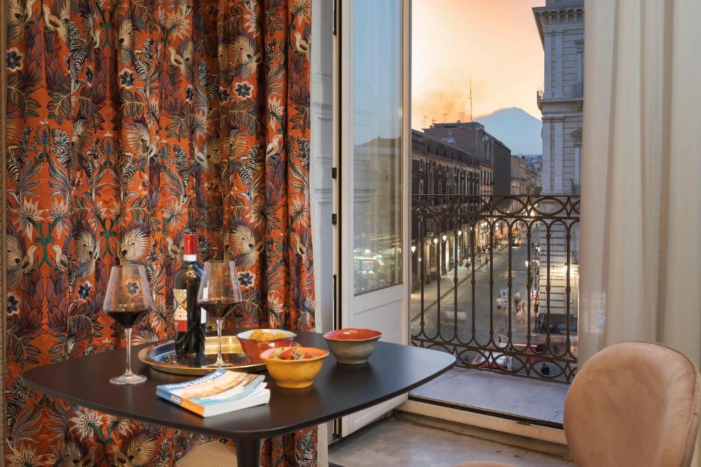 a table on a balcony with a view of a city at Belduomo Catania Rooms & Flat in Catania