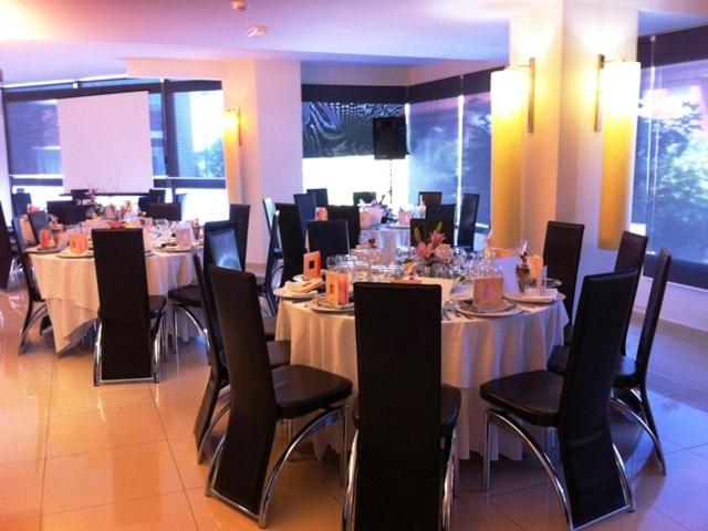 un comedor con mesas y sillas con mantel blanco en Hotel Diego's en Cambrils