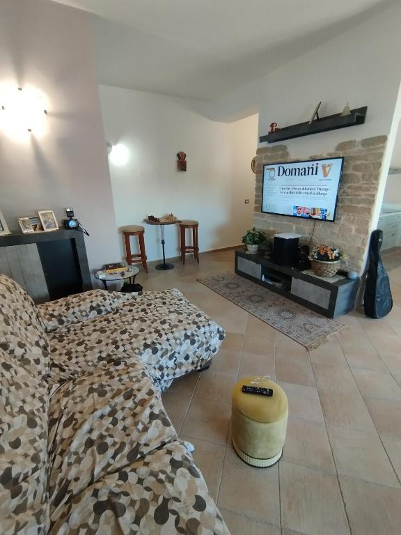 Una sala de estar con un sofá y un televisor de pantalla plana. en Mira Beach, en Praia a Mare