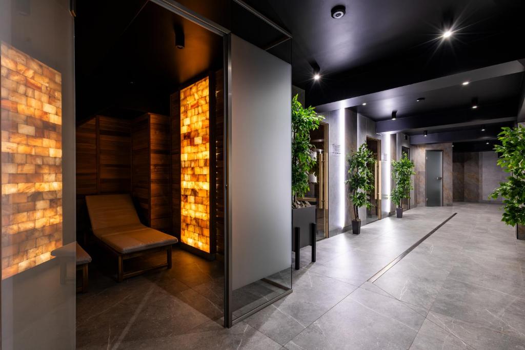 a hallway with a chair and plants in a building at Hotel Alpin in Szczyrk