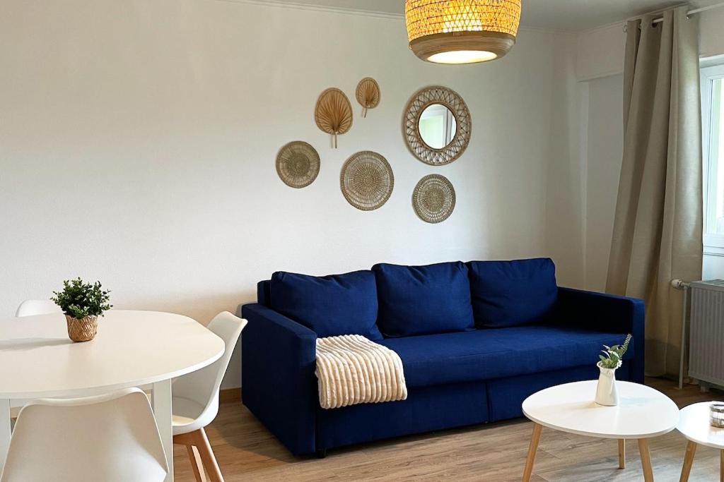 a living room with a blue couch and a table at LE COSY Basel Euroairport ! Parking Privé in Saint-Louis
