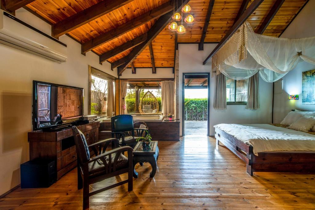 a bedroom with a bed and a desk and a chair at צימרים טרה נוסטרה in Had Nes