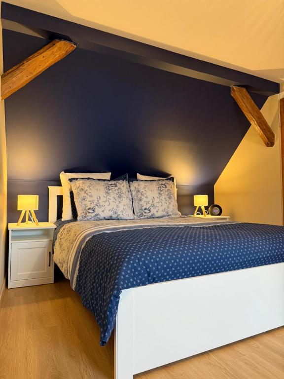 a bedroom with a large bed with a blue wall at S'Nekel Hisel - Gîte à Offwiller in Offwiller