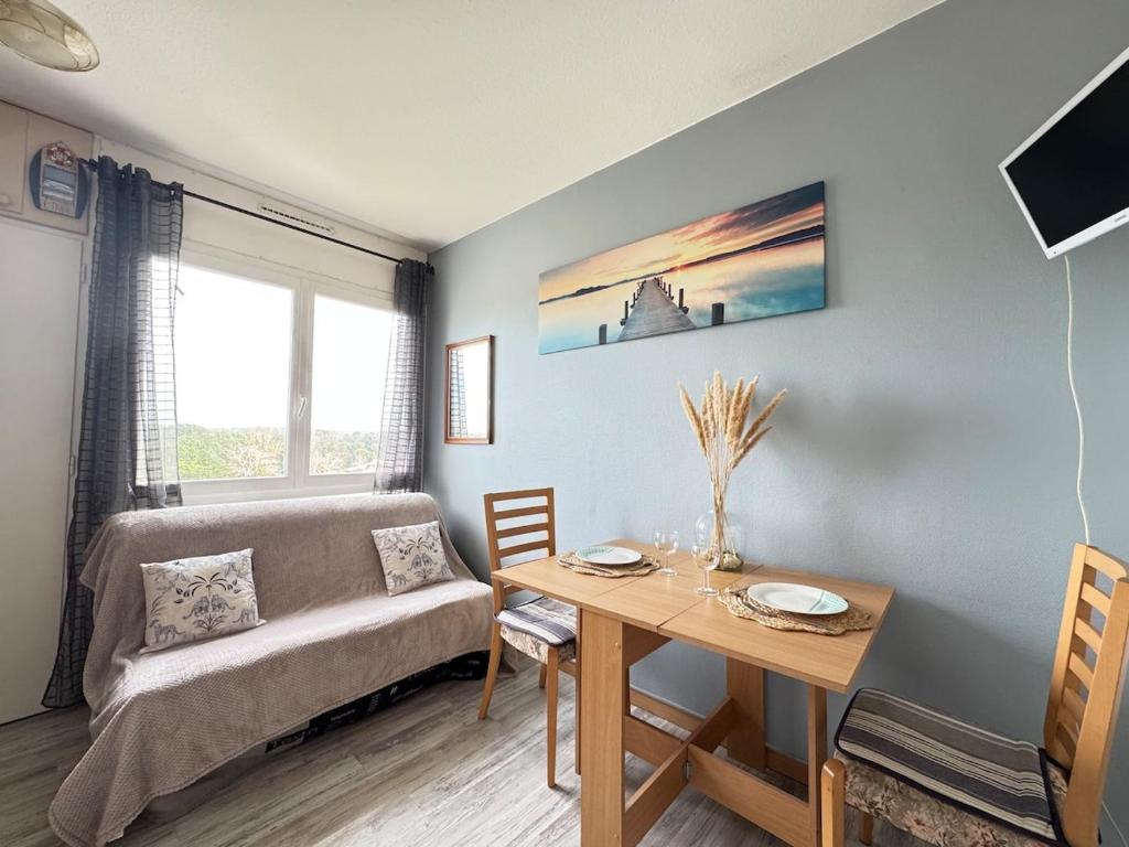 a living room with a couch and a table at Le Pignon - TV, 1min de la Mer, Central in Saint-Jean-de-Monts