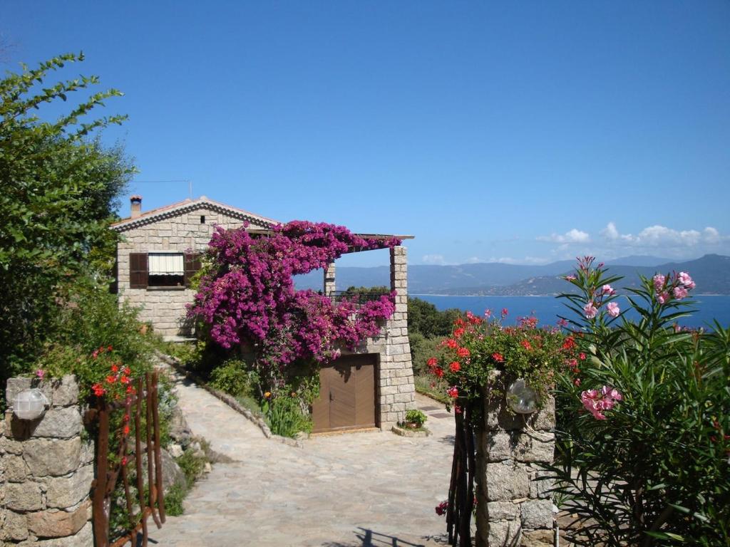 a house with a bunch of flowers on it at Maison de Charme Vue Exceptionnelle Mer & Montagne in Campomoro