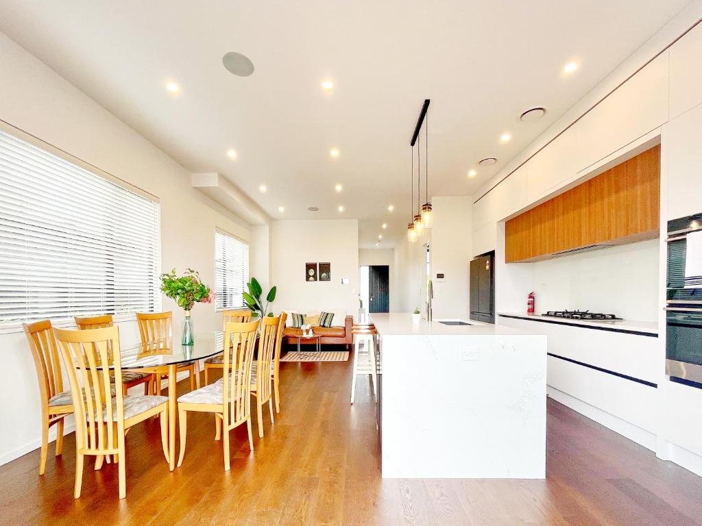 a kitchen and dining room with a table and chairs at Spacious 7 BRs 4 BHs house on Longhorn, Flat Bush in Auckland