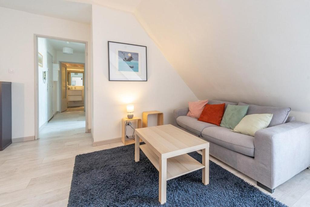 a living room with a couch and a table at Bel appartement au centre Colmar stationnement in Colmar