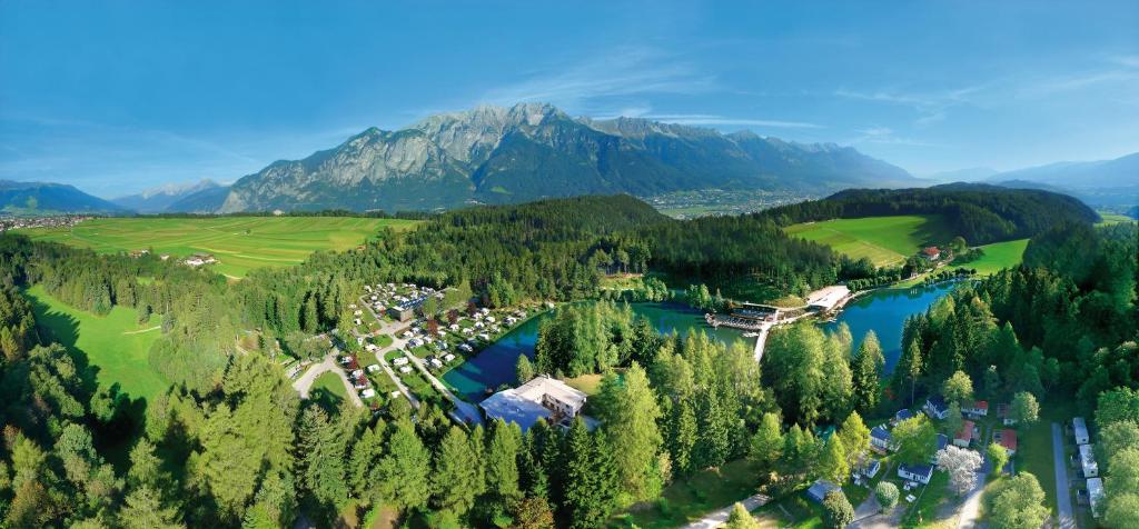 eine Luftansicht eines Resorts mit See und Bergen in der Unterkunft Ferienparadies Natterer See in Innsbruck