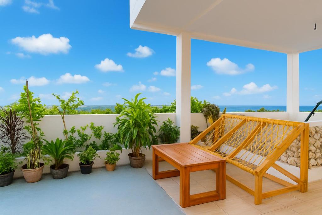 a porch with a hammock and potted plants at Olhumathi View Inn in Ukulhas