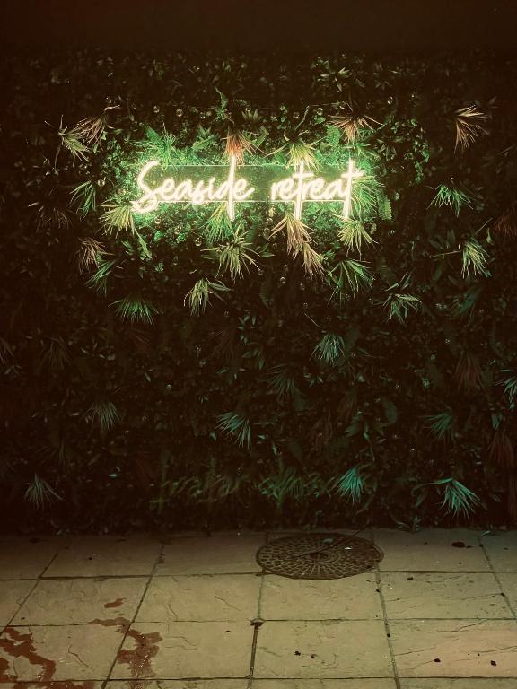 a neon sign that says smile ahead on a bush at Seaside Retreat in Harrington