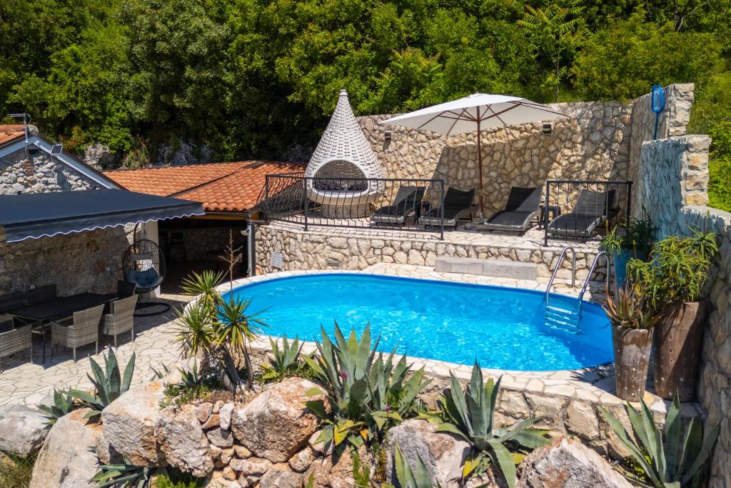 a swimming pool in a yard with an umbrella at Paun in Bribir