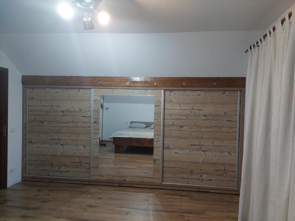 a bedroom with a large wooden wall with a bed at ANNA Home in Craiova