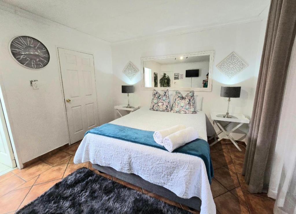 een slaapkamer met een groot bed en een spiegel bij Zhantique Guest House 1- Unit 5 in Boksburg