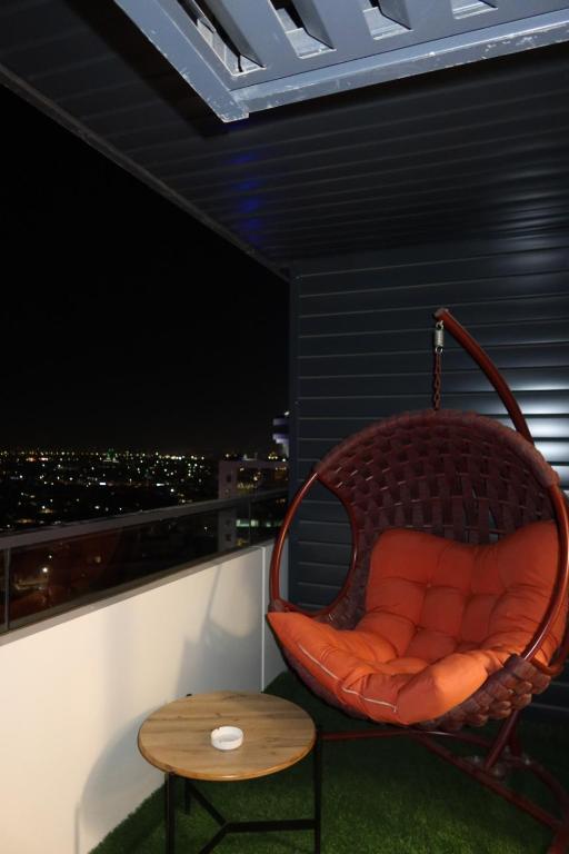 a wicker chair sitting on a balcony with a table at Аренда квартиры #19 NRG U-Tower Rent an apartment in Tashkent