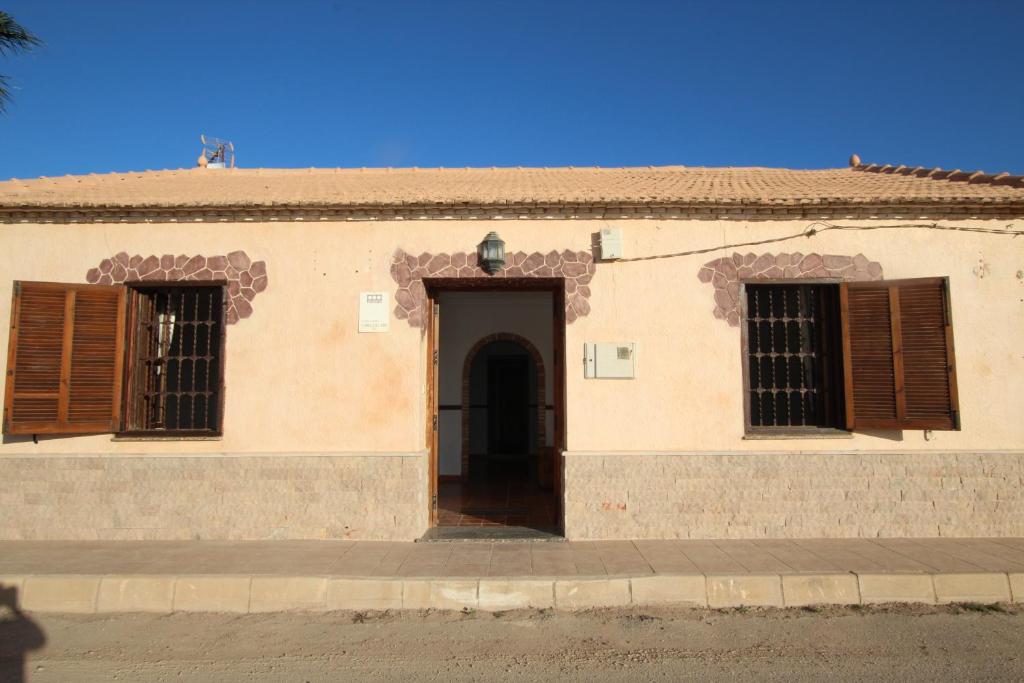 un edificio con una puerta y dos ventanas en La Casona del Olivo, en Torre-Pacheco