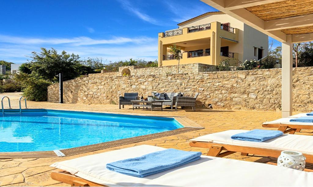 a villa with a swimming pool and a house at Ferienhaus Für 16 Personen In Episkopi, Kreta West Kreta in Episkopí- Rethimno