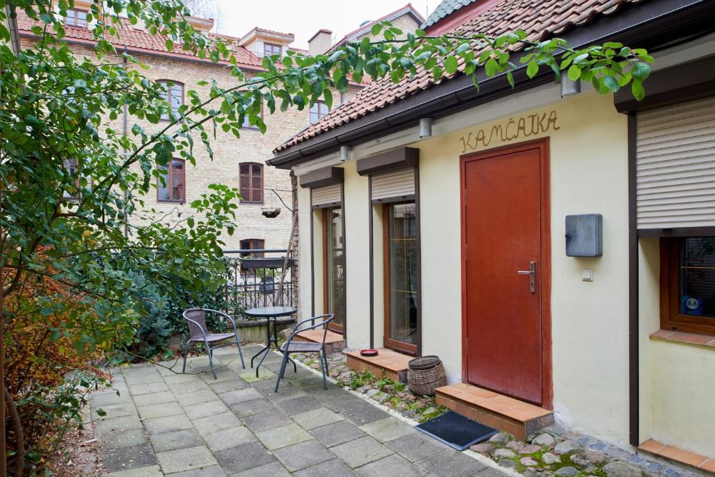 un patio avec une table et des chaises à côté d'un bâtiment dans l'établissement Boutique Cottage, à Vilnius