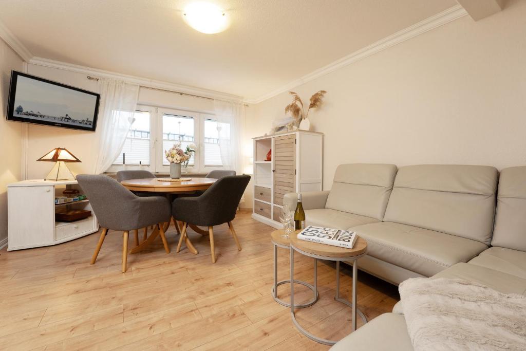 a living room with a couch and a table at Heckenröschen in Grömitz