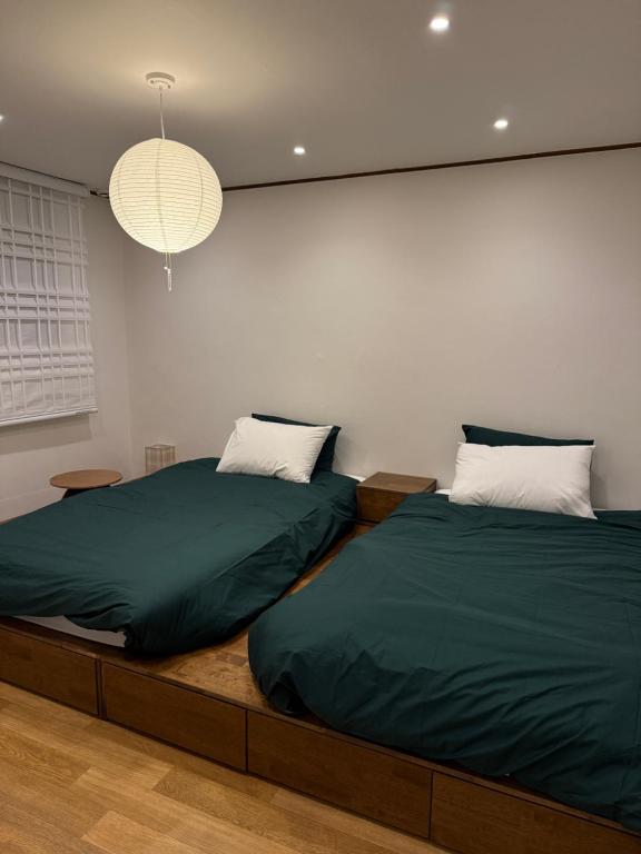 Dos camas una al lado de la otra en un dormitorio. en Sodamjae Stay, near Seokchon Lake 5 guests, en Seúl