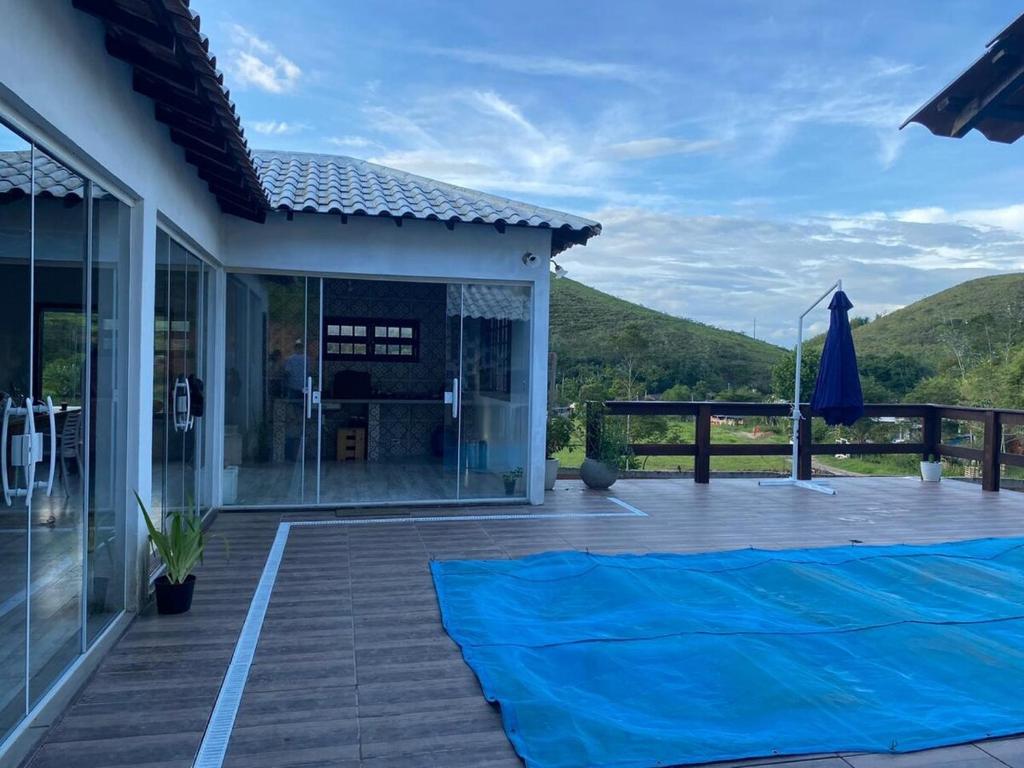 ein Haus mit einer blauen Plane auf der Terrasse in der Unterkunft Casa Blanca - Casa na Serra in Piraí