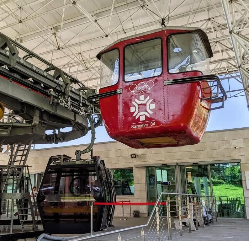 un tren rojo colgando del techo de un edificio en Uspinjaca, en Sarajevo