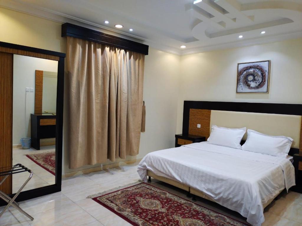 ハミース・ムシャイトにあるشقق همسات انتور المخدومةの大きな白いベッドと鏡のある寝室