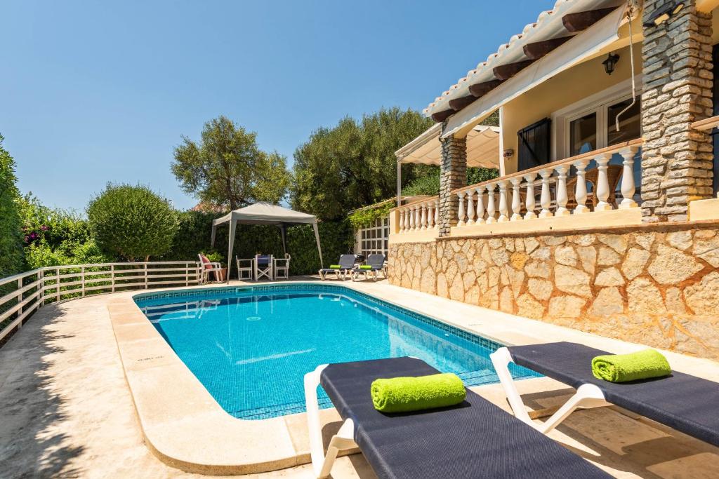 a villa with a swimming pool and a house at Villa Mari - con piscina privada y jardin en Calan Porter in Cala en Porter