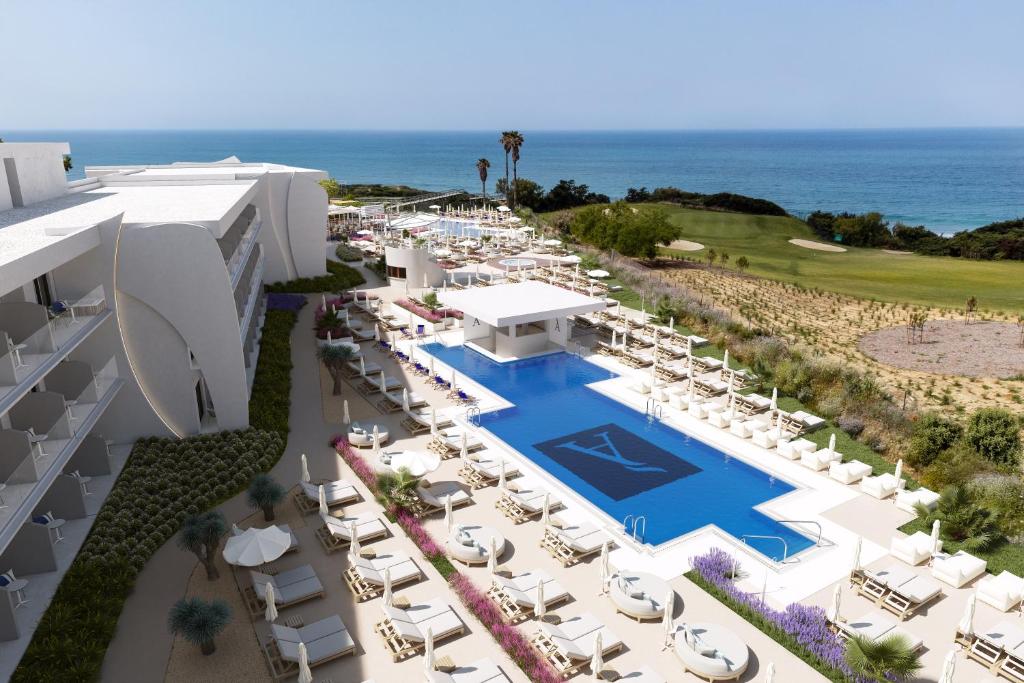 Una vista aérea de un resort con piscina y sillas. en Amare Beach Hotel Sancti Petri - Adults Recommended, en Chiclana de la Frontera