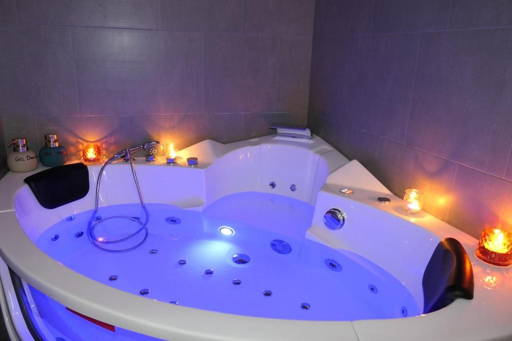 eine weiße Badewanne mit Lichtern in einem Badezimmer in der Unterkunft Good Vibes Room in Moissac