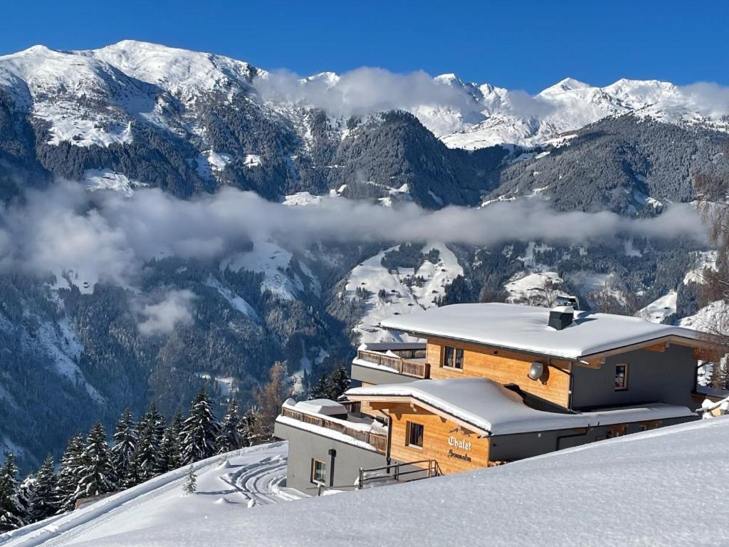 una casa en la cima de una montaña cubierta de nieve en SonnenChalet Schlittenstadl, en Ramsau im Zillertal