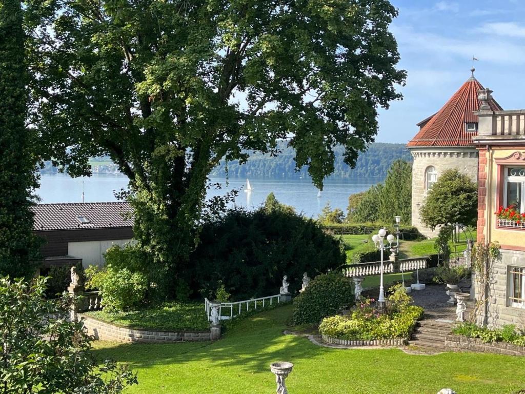 a house with a tree and a lake in the background at Am Gallerturm mit Seeblick in Überlingen