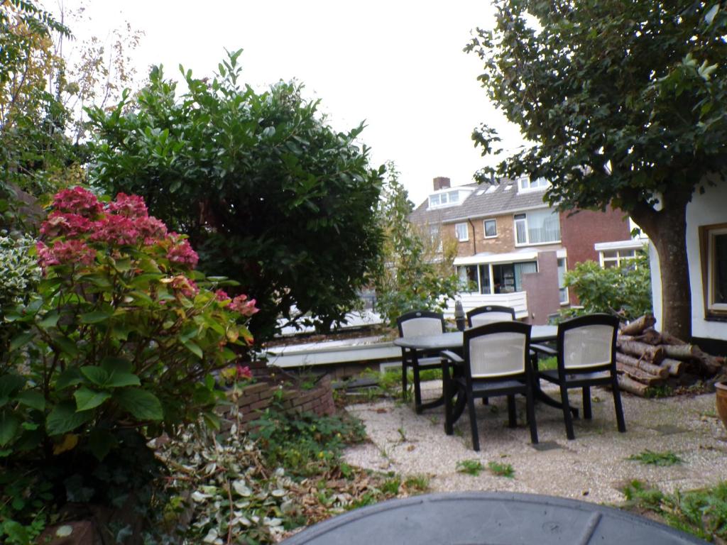 a backyard with a table and chairs and flowers at Beach Quarter in Ons Belang