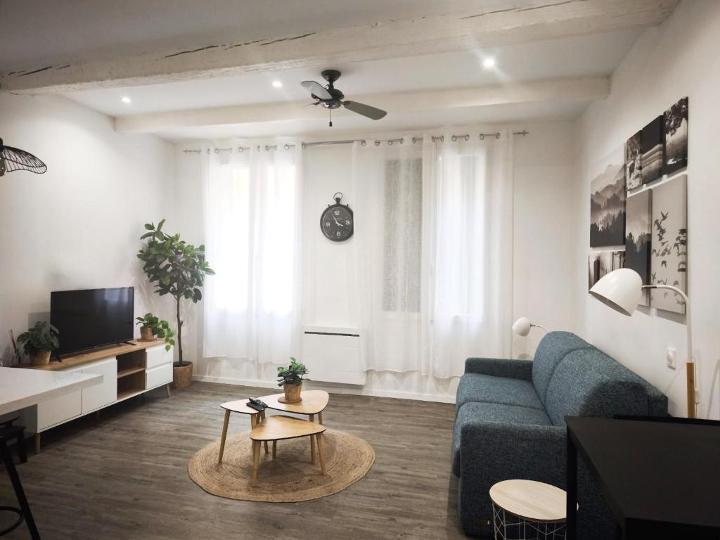 a living room with a blue couch and a tv at Bon Pasteur in Aix-en-Provence