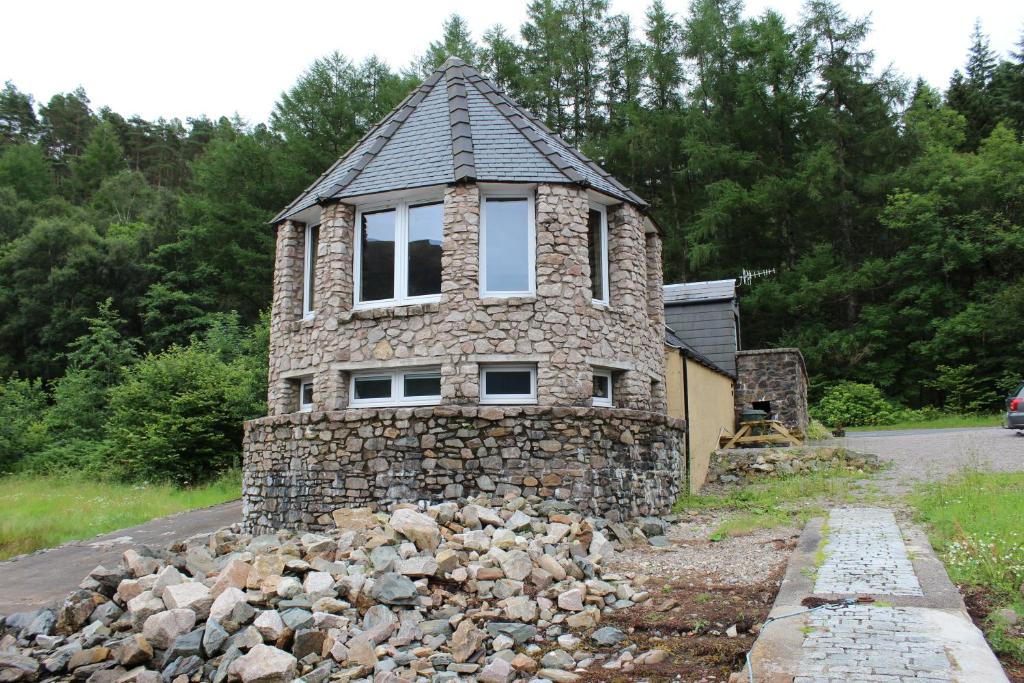 
a stone building with a stone wall at The Boathouse in Glencoe
