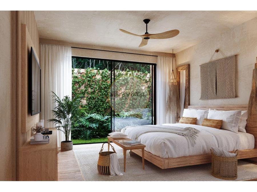 a bedroom with a bed and a large window at HEBE Hotel & Hostel in Sawah