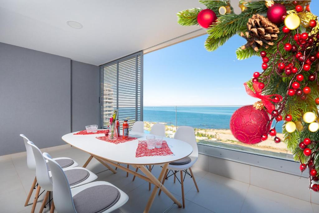 a dining room with a christmas tree and a table and chairs at Fidalsa Paradise Sea Punta Prima in Torrevieja