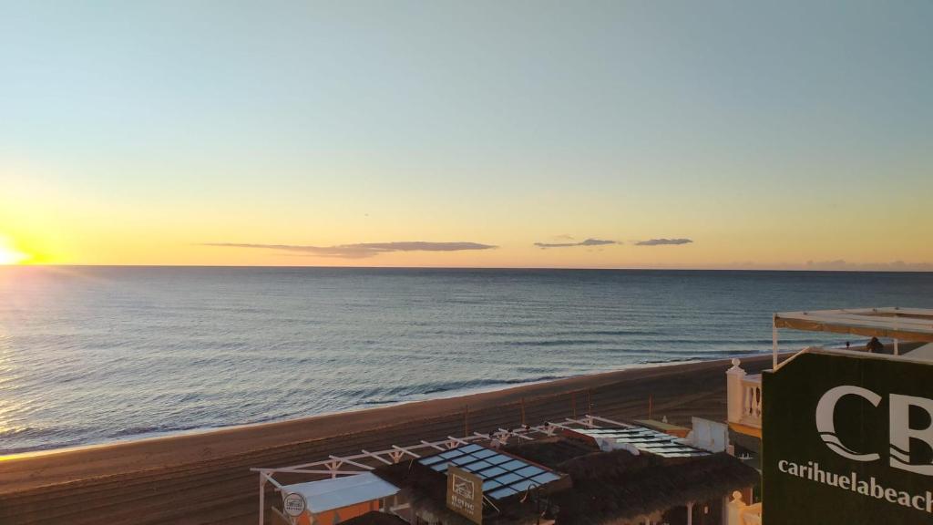 a view of the ocean at sunset from a resort at Carihuela Beach Apartamentos in Torremolinos