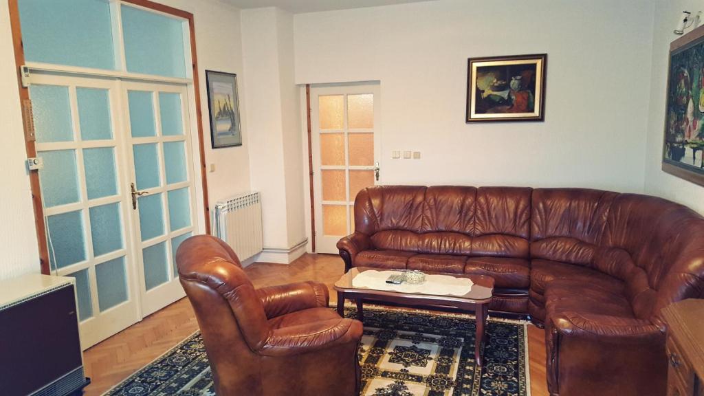 a leather couch and two chairs in a living room at Apartman Milija in Trebinje