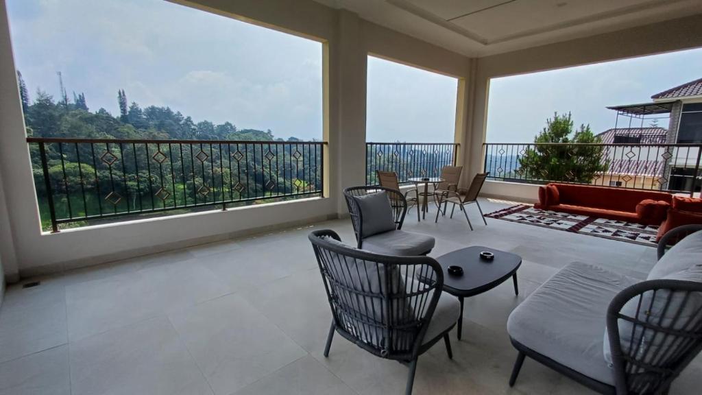 a large living room with chairs and a large window at فيلا جولدن فلور بونشاك in Tagalbato