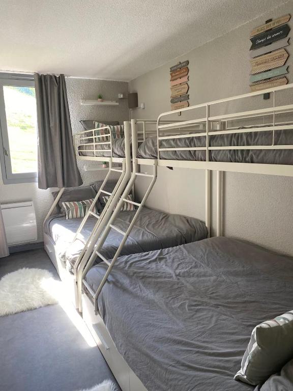 two bunk beds in a room with a window at Le Portail 76 in Valmorel