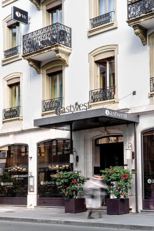a person walking in front of a building at Eastwest Hôtel by Malone in Geneva