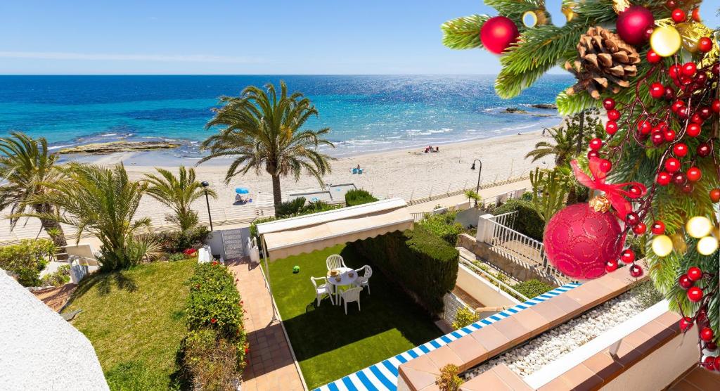 ein Blick auf den Strand von einem Balkon mit einem Weihnachtsbaum in der Unterkunft Fidalsa Famous Spot in Dehesa de Campoamor