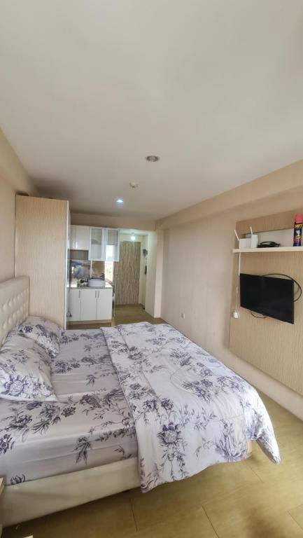 a bedroom with a large bed and a kitchen at Jendela360 in Jomblang