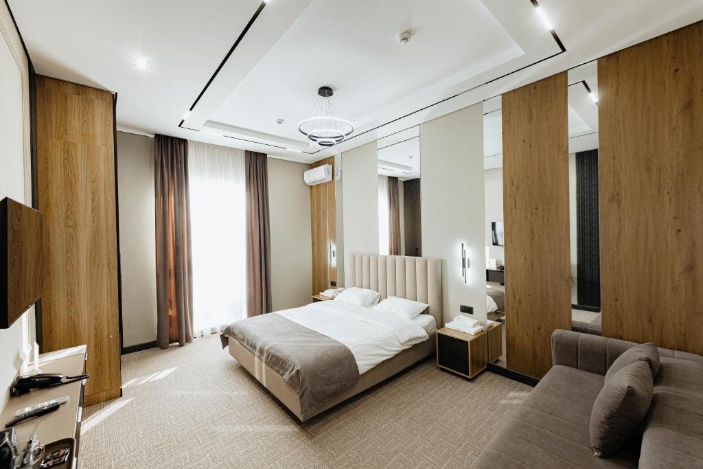 a hotel room with a bed and a couch at Residence Hotel Spa in Taraz