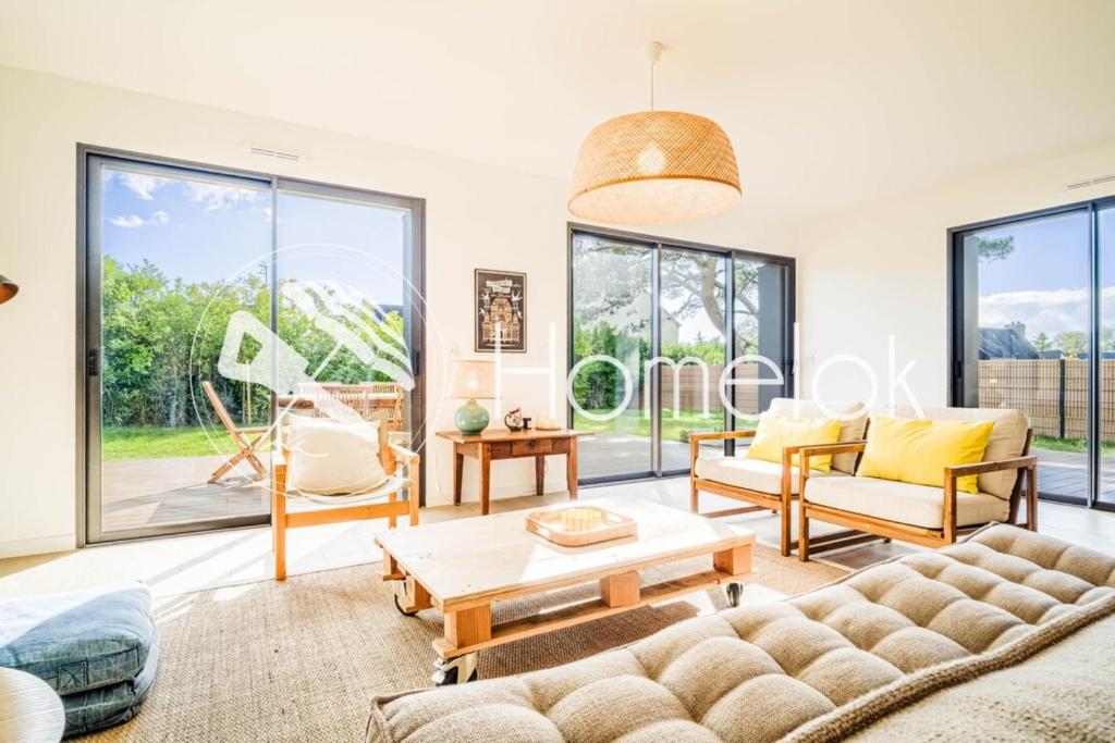a living room with a couch and a table at Belle maison moderne proche plages & bourg in Carnac
