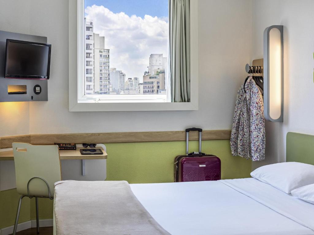 a hotel room with a bed and a window at ibis budget Sao Paulo Jardins in Sao Paulo