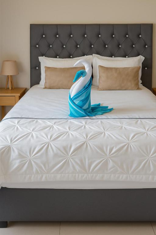a bed with a blue dress on it at EE Maison Bed and Breakfast in Francistown