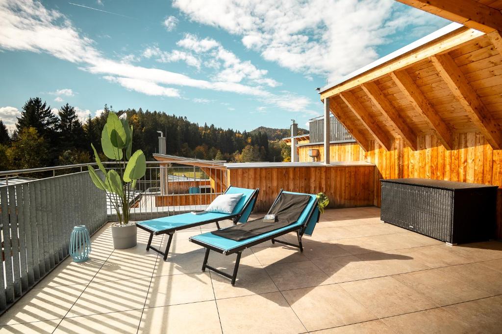 un patio con dos sillas y una mesa en OpenSky Wörthersee Lodge, en Pörtschach am Wörthersee